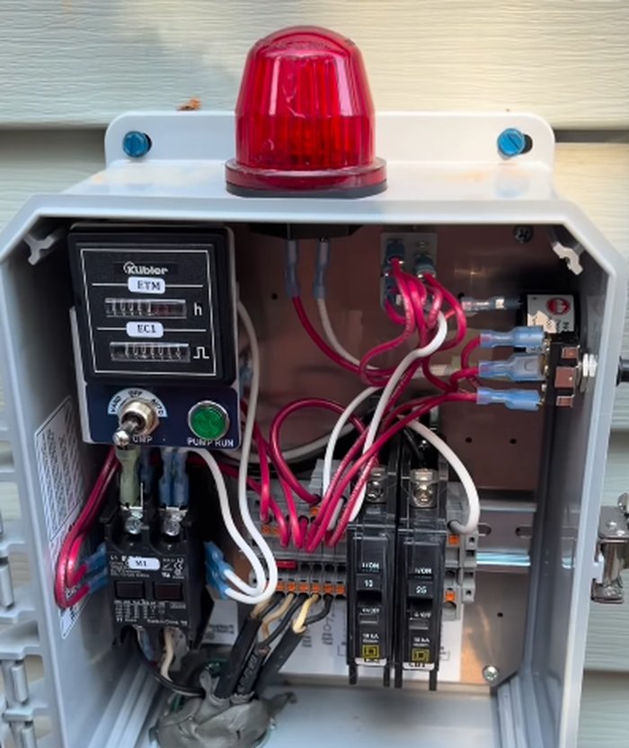 Septic control panel and alarm box installed on the exterior of a home