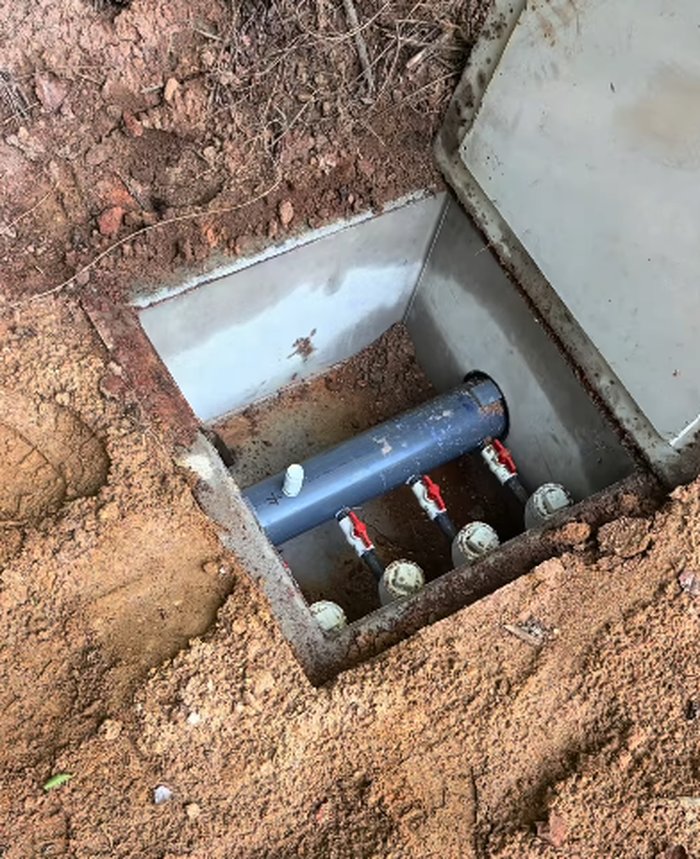 Close-up of septic distribution box valves and pipe connections